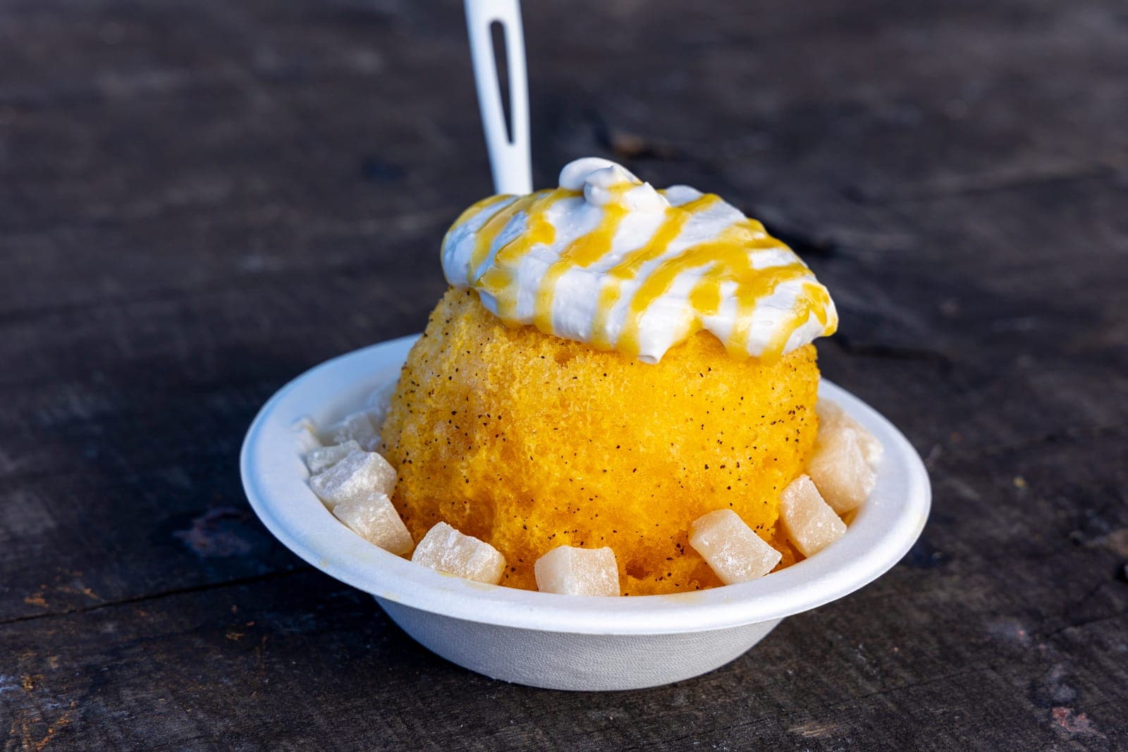 A loaded Hawaiian shave ice — fine snowy ice with mochi, haupia coconut cream, and a lilikoi passion-fruit drizzle